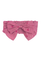 The Perfect in Pink Hair Clip Accessory by Mabel and Honey features an elastic, ruched band and a statement bow with a charming red heart pattern.
