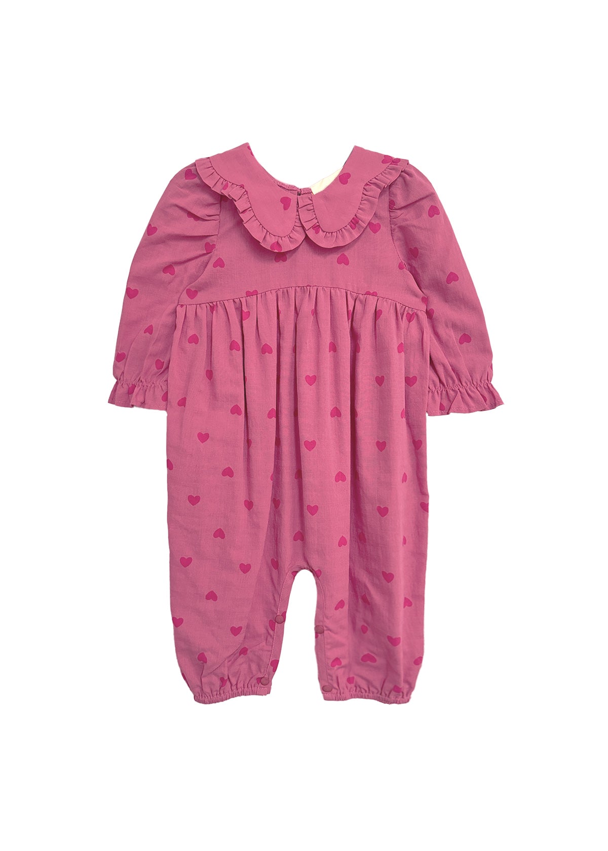 The Perfect in Pink Romper by Mabel and Honey is a baby girl romper featuring long sleeves, a ruffled collar, elasticized cuffs and ankles, and a cute dark pink heart pattern for a sweet, playful look.