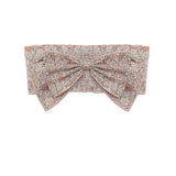 The Emmaline Hair Accessory by Mabel and Honey is a vintage-inspired headband with a soft pink and gray floral pattern, oversized bow, and crisp white background.