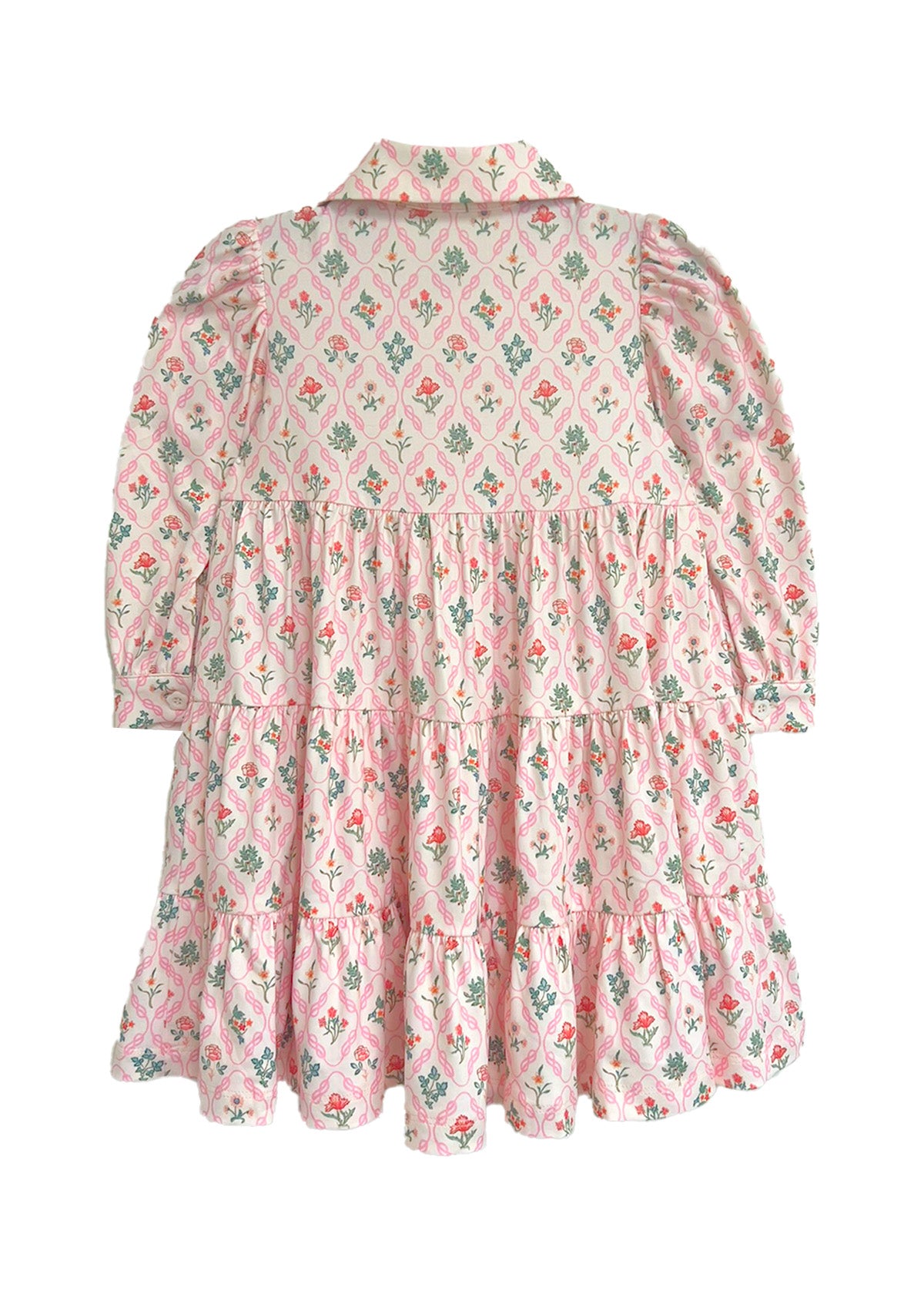 The Dixie Pink Floral Dress by Mabel and Honey features a vintage-inspired tiered silhouette with long sleeves, a collar, and gathered panels for a ruffled pink skirt accented with green and red floral designs.