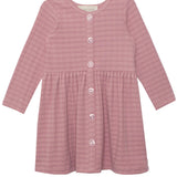 The Liliana Plaid Dress by Mabel and Honey is a childrens long-sleeve, dusty pink plaid dress with a round neckline, front button closure, gathered waist, and an A-line skirt.