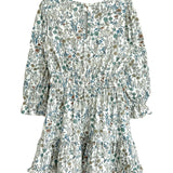 The Brooklyn Floral Dress by Mabel and Honey is a girls' knee-length dress in green, blue, and brown floral on white with long sleeves, a gathered waist, ruffled hem, and button-back closure.