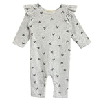 The Heartfelt Romper by Mabel and Honey features ruffled shoulders and tiny black hearts on gray fabric, making an adorable baby outfit. Shown against a white backdrop.