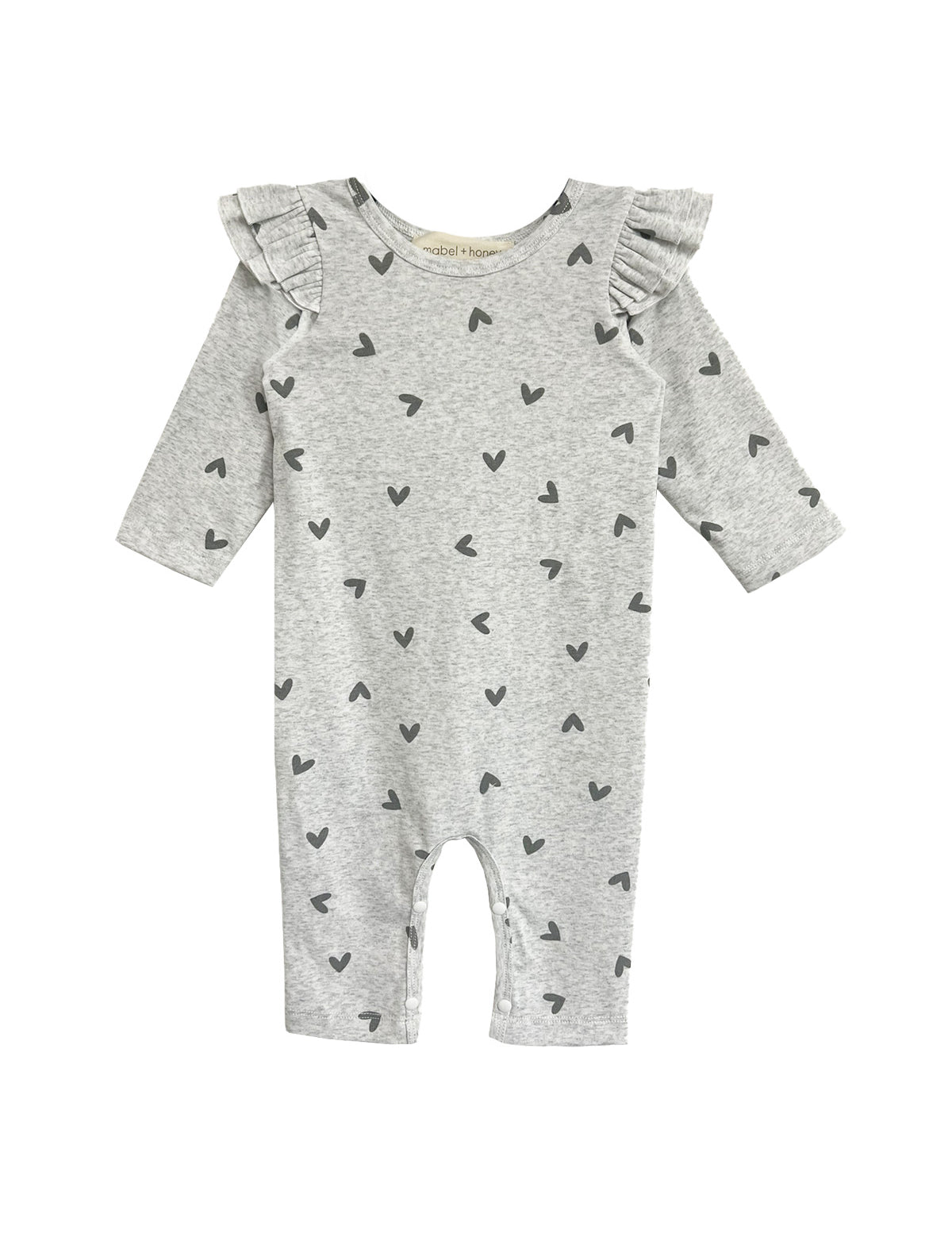 The Heartfelt Romper by Mabel and Honey features ruffled shoulders and tiny black hearts on gray fabric, making an adorable baby outfit. Shown against a white backdrop.