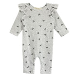 The Heartfelt Romper by Mabel and Honey features ruffled shoulders and tiny black hearts on gray fabric, making an adorable baby outfit. Shown against a white backdrop.