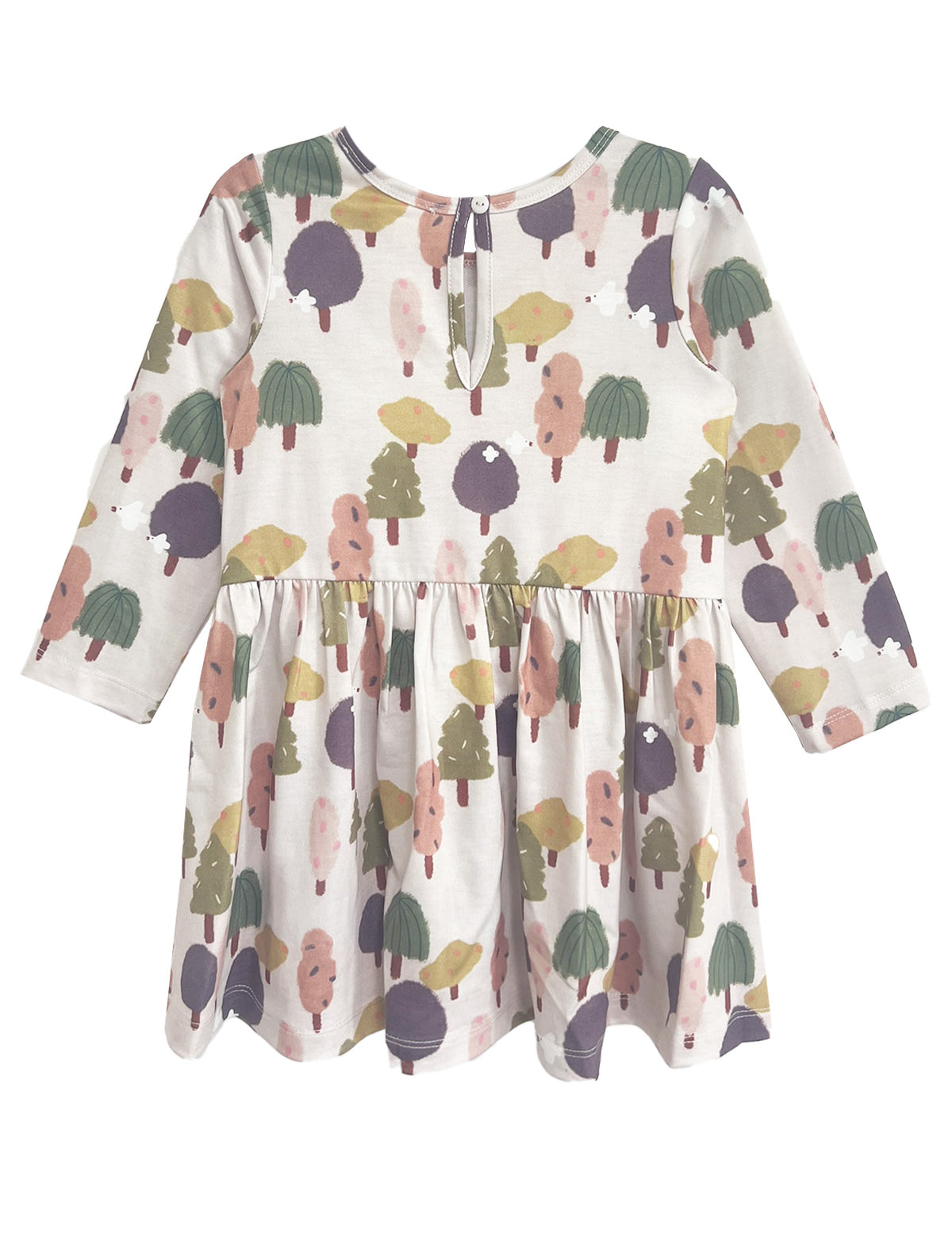 The Mabel and Honey Treehouse Dress is long-sleeved with a gathered waist, showcasing whimsical trees in muted green, purple, pink, and yellow on a light background. A keyhole button at the back adds a charming, nature-inspired touch.