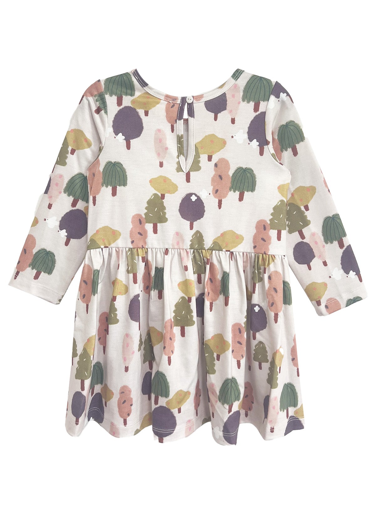 The Mabel and Honey Treehouse Dress is long-sleeved with a gathered waist, showcasing whimsical trees in muted green, purple, pink, and yellow on a light background. A keyhole button at the back adds a charming, nature-inspired touch.