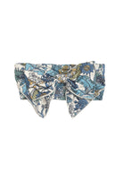 The Leah Hair Accessory by Mabel and Honey is a floral headband with a large bow, featuring a charming blue, green, and white print.
