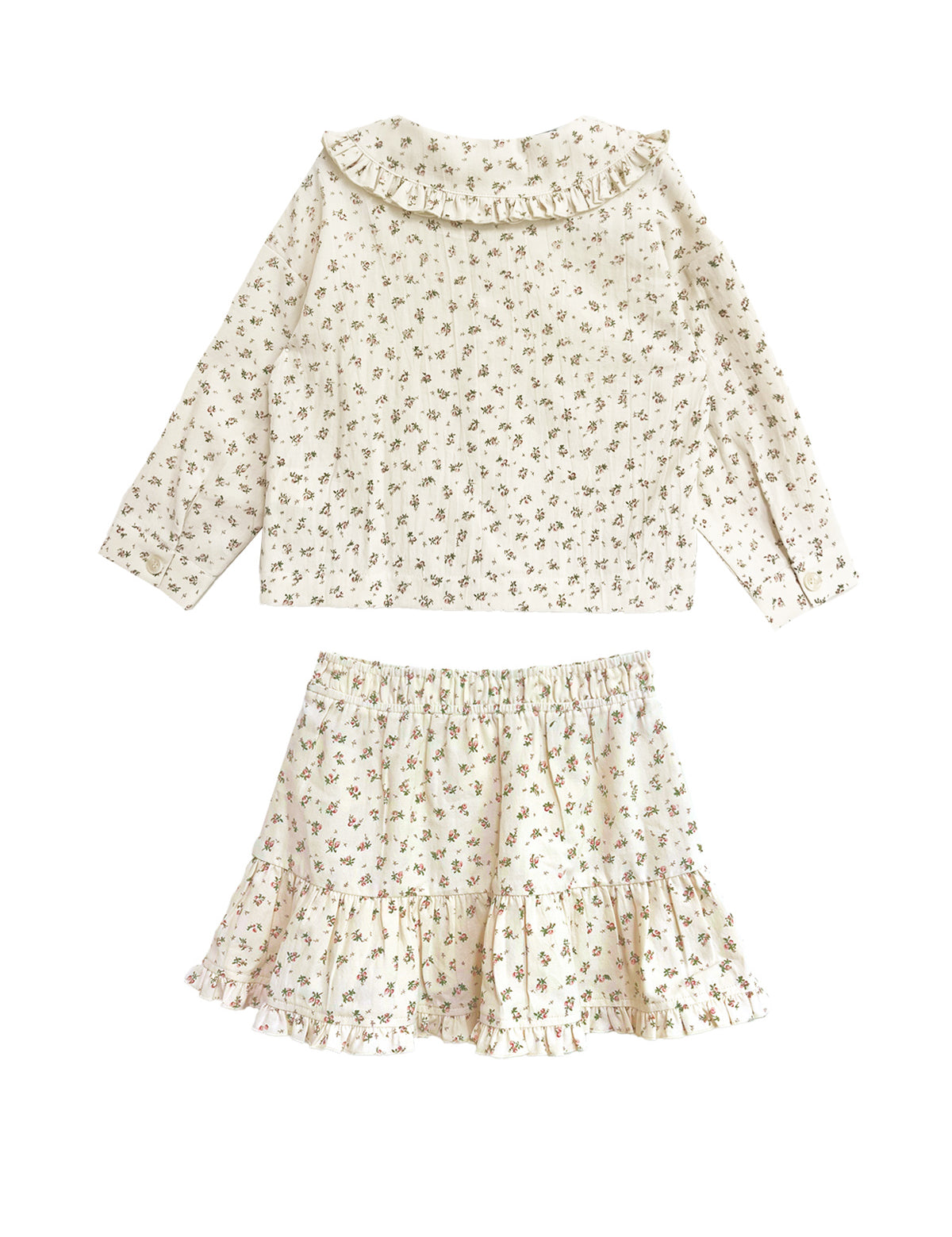 The Juliette Two Piece Set by Mabel and Honey is a charming girls’ outfit featuring an off-white long-sleeve top with ruffle collar and a matching floral ruffle skirt.