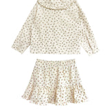 The Juliette Two Piece Set by Mabel and Honey is a charming girls’ outfit featuring an off-white long-sleeve top with ruffle collar and a matching floral ruffle skirt.