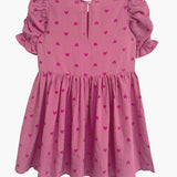 The Mabel and Honey Perfect in Pink Hearts Short Sleeve Dress for girls features a gathered skirt, short puffed sleeves, darker pink heart prints, and a back button closure.