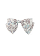 The Mabel and Honey Meadow Hair Accessory is a lightweight fabric bow for baby girls, featuring brown and light blue floral patterns on white. Shown against a plain white backdrop.