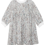 The Meadow Dress by Mabel and Honey is a girls’ long-sleeved floral dress with a white background, blue and grey print, gathered waist, and white cuffs—ideal for comfortable everyday wear.