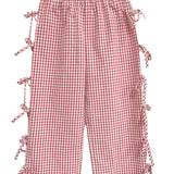 The Bow-tastic Pant by Mabel and Honey features red and white gingham, an elastic waistband, side slits with bow accents, and a wide-leg cropped fit—adding playful charm to any outfit.