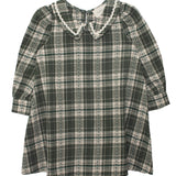 The Plaid & Pine Dress by Mabel and Honey is a girls' long-sleeve, knee-length dress with a green and white plaid pattern, Peter Pan collar, and delicate white lace trim at the neckline.