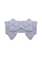 The Lana Hair Accessory by Mabel and Honey features a wide lavender fabric belt with a large center bow, subtle small flower pattern, and an elastic back—making it a charming touch for your baby girl.
