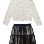 The Bow Chic Two Piece Set by Mabel and Honey features a cream long-sleeve top with black bow print and ruffled edges, paired with a layered black lace skirt topped with a cute bow at the waistband.