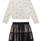 The Bow Chic Two Piece Set by Mabel and Honey features a cream long-sleeve top with black bow print and ruffled edges, paired with a layered black lace skirt topped with a cute bow at the waistband.