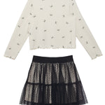 The Bow Chic Two Piece Set by Mabel and Honey features a cream long-sleeve top with a bow print and a black tiered tulle lace skirt with an elastic waistband, displayed flat on a white background.
