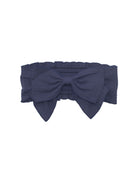 The Clara Hair Accessory by Mabel and Honey is a dark blue headband with an oversized center bow and an elastic back for a secure fit.