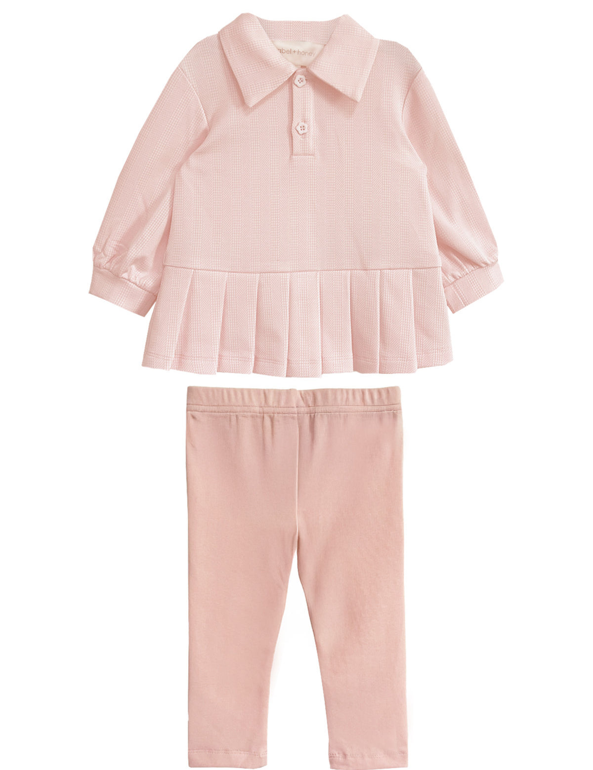 The Serena Two Piece Set by Mabel and Honey is a light pink girls’ outfit with a long-sleeve, collared top featuring a pleated hem and matching elastic-waist pants, both crafted from soft fabric.