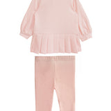 The Serena Two Piece Set by Mabel and Honey is a pink girls’ outfit with a long-sleeve top featuring a pleated hem and collar, paired with matching elastic-waist leggings, shown on a white background.