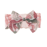 The Bow-tiful Hair Accessory by Mabel and Honey is a charming pink hairband for baby girls, featuring a large bow with a pink and green leaf pattern—perfect for any occasion.