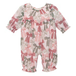 The Mabel and Honey Bow-tiful Romper is a long-sleeve baby girls’ outfit with a ruffle neckline and cuffs, featuring pink, red, and green bows on a white background.