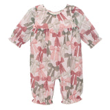 The Mabel and Honey Bow-tiful Romper is a long-sleeve baby girls’ outfit with a ruffle neckline and cuffs, featuring pink, red, and green bows on a white background.