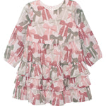 The Bow-tiful Dress by Mabel and Honey is a girls’ long sleeve dress with playful tiers, ruffles, and a pink-and-green bow print on crisp white.