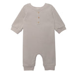 The Isaac Romper by Beckett and Bear showcases a light gray, neutral design with ribbed cuffs, a round neckline, three wooden chest buttons, and leg snap closures. The soft fabric ensures comfort for your baby.
