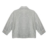 The Grayson Jacket by Beckett and Bear is a light gray corduroy kids layering jacket with long sleeves, a collar, and buttoned cuffs. Shown from the back on a white background, its subtle textured pattern adds stylish detail.