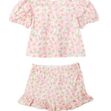 The Wild Savanna Short Gathered Sleeve Two Piece Set by Mabel and Honey features a pink, yellow, and green floral print with a ruffled short-sleeve top and matching elastic-waist shorts with ruffled hems.