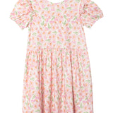 The Wild Savanna Short Gathered Sleeve Dress by Mabel and Honey is a lightweight, knee-length dress with ruffled sleeves, featuring a pink floral print with green leaves on a white background and a gathered waist.