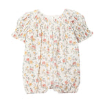 The Mabel and Honey Audrey Flutter Sleeve Romper is a white baby romper with short puff sleeves, elastic leg openings, and a charming pink, yellow, and green floral pattern for comfort and style.