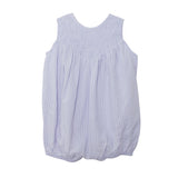 The Magnolia Sleeveless Romper by Mabel and Honey features light purple and white vertical stripes, a smocked yoke, and a gentle bubble silhouette. Shown on a white background.