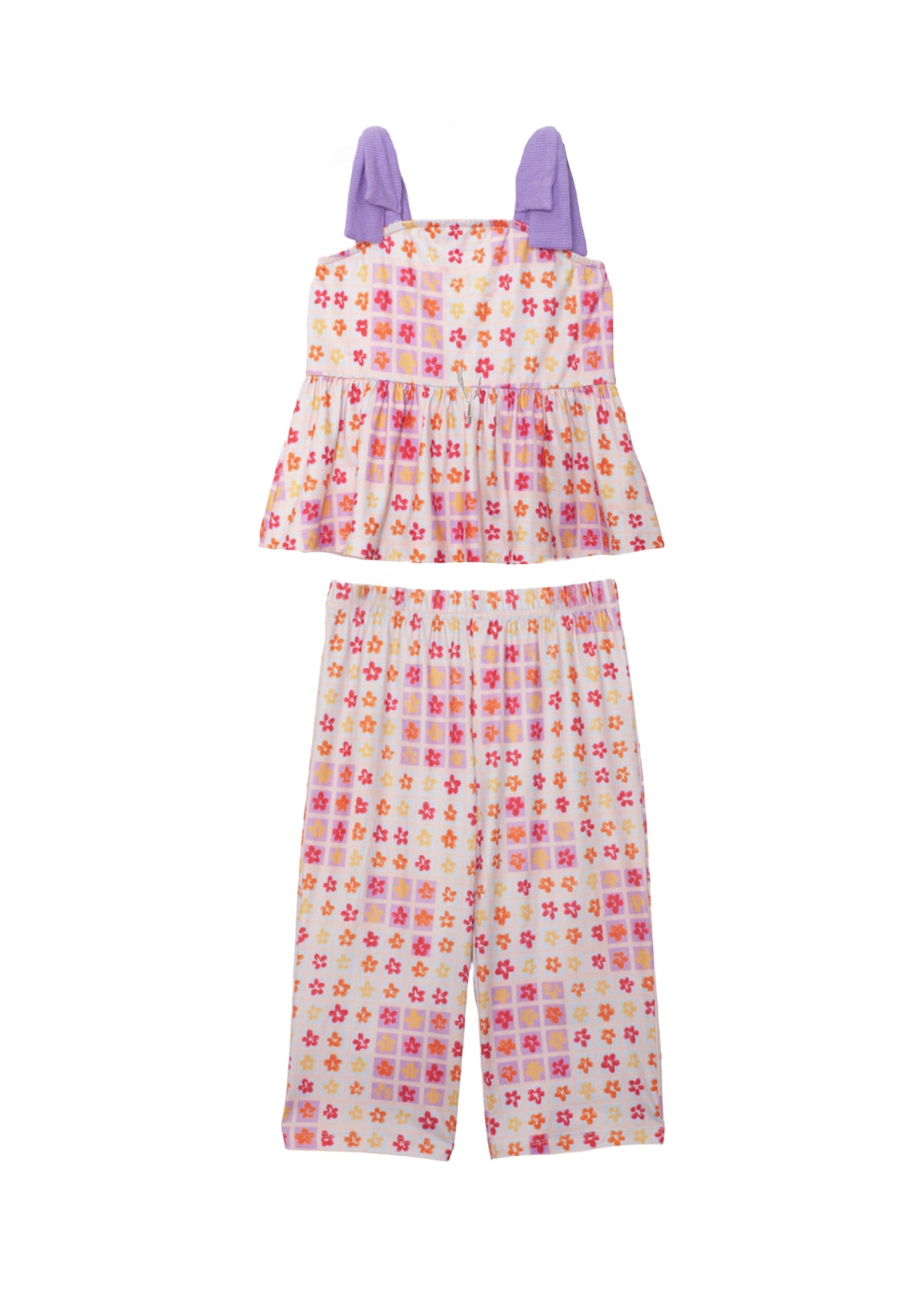 The Mabel and Honey Petal Power Tank Sleeve with Knot Detail Two Piece Set features a sleeveless peplum top with purple bows and wide-leg pants, both in a vibrant pink, orange, and purple geometric floral print on cream.