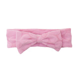 The Tilly Hair Accessory by Mabel and Honey is a soft pink terrycloth headband with a textured pattern and a large center bow, making it both adorable and comfortable.