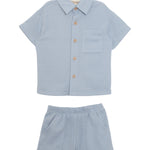 The Beckett and Bear Rowland Short Sleeve Two Piece Set features a light blue checkered shirt with brown buttons and chest pocket, plus matching shorts. Both pieces are laid flat on a white background.