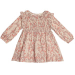 The Autumn Floral Tan Long Sleeve Dress by Mabel + Honey features a red floral pattern, smocked front bodice, ruffled shoulders, flared skirt, and elastic cuffs for comfort. Perfect for toddlers.