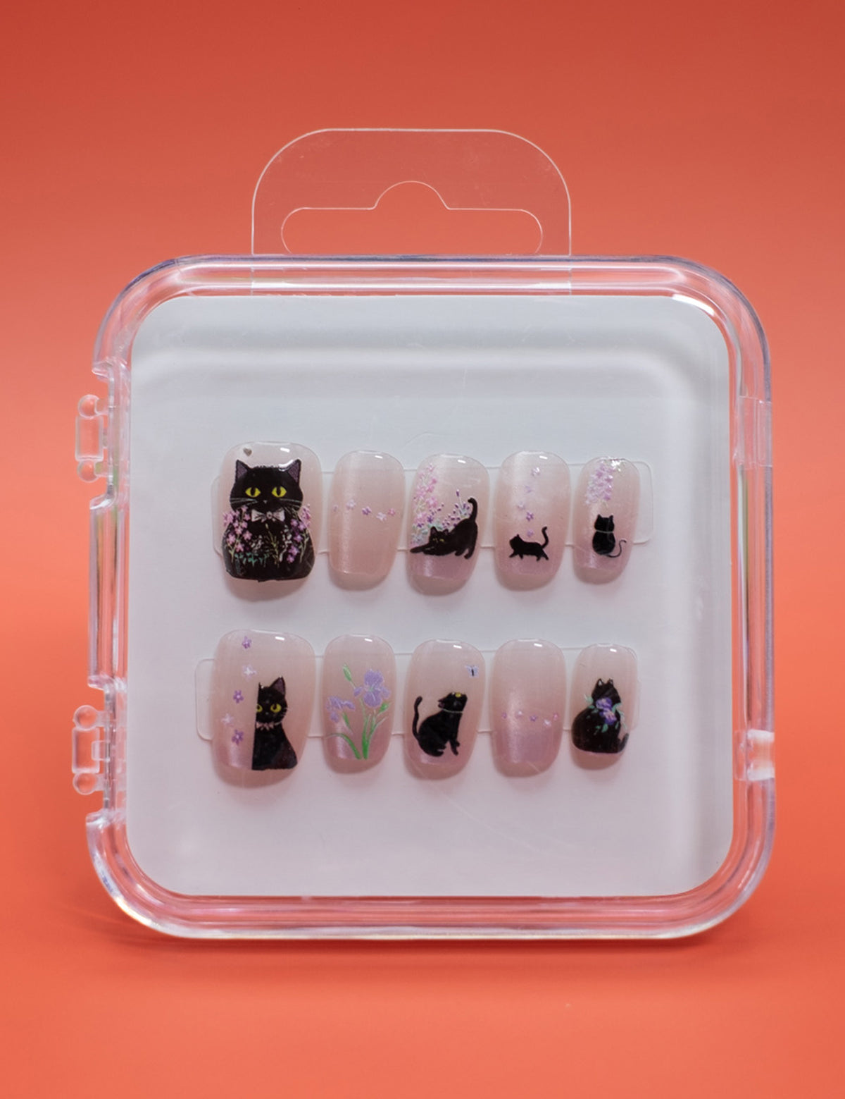 Cat Blossom by Mabel and Honey offers reusable press-on nails in a clear case, each nail featuring black cat designs with floral accents—perfect for achieving a salon-quality manicure at home.