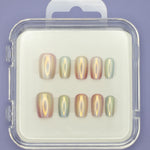 The "Seashells" by Mabel and Honey features ten salon-quality press-on nails in assorted sizes, elegantly arranged in a clear plastic case on a white background with a light purple surface underneath.