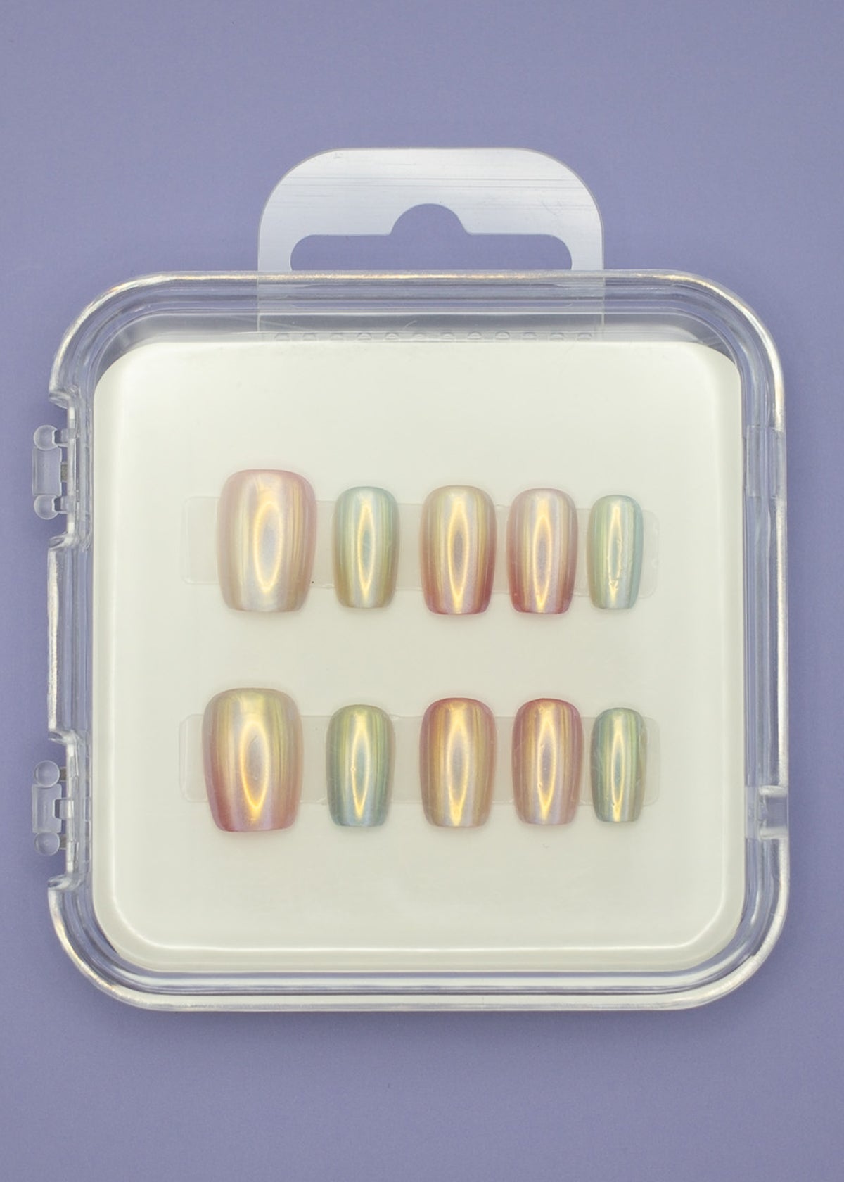 The "Seashells" by Mabel and Honey features ten salon-quality press-on nails in assorted sizes, elegantly arranged in a clear plastic case on a white background with a light purple surface underneath.
