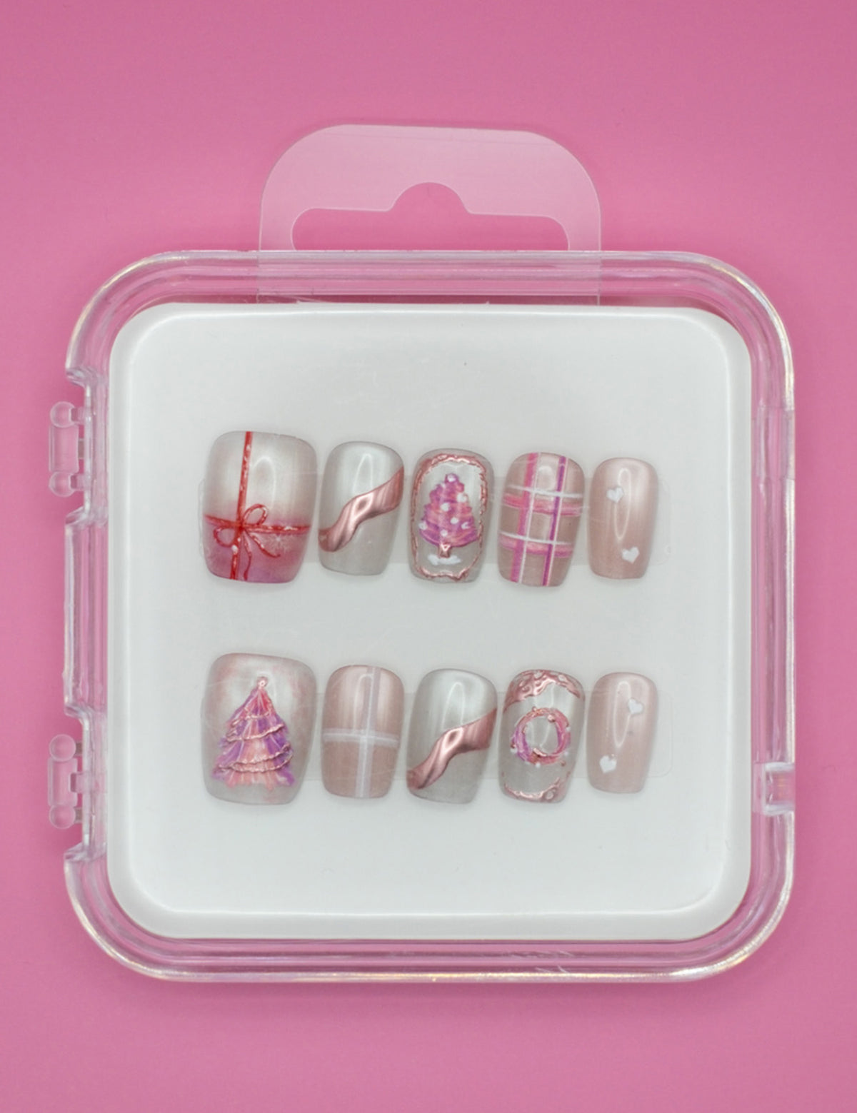 Mabel and Honey’s Holiday Blush features reusable pink and white press-ons with bows, plaid, and Christmas trees in a plastic case—perfect for salon-quality manicures at home.