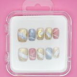 Sweet Dreams by Mabel and Honey: a set of 10 salon-quality press-on nails with pastel blue, pink, and beige swirls, gold stars, moons, and abstract lines. Reusable manicure in a clear case on a pink background.