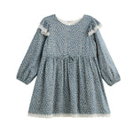 The Dolly Dress Long Sleeve Floral Lace Trim Empire Waist Dress by Mabel + Honey features a slate blue hue with a white floral pattern, delicate lace trim on the sleeves and hem, a gathered empire waist, and a classic round neckline. Made from a lightweight cotton blend for all-day comfort.