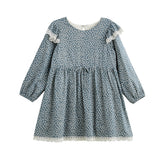 The Dolly Dress Long Sleeve Floral Lace Trim Empire Waist Dress by Mabel + Honey features a slate blue hue with a white floral pattern, delicate lace trim on the sleeves and hem, a gathered empire waist, and a classic round neckline. Made from a lightweight cotton blend for all-day comfort.