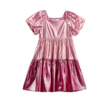 The Mabel + Honey Berry Blush Dress is a shiny metallic pink short-sleeve girls’ party dress featuring puffed sleeves, a square neckline, and a color-blocked tiered skirt, displayed on a white background.