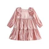 The Isobella and Chloe Rosy Glow Long Sleeve Metallic Ruffle Trim Tiered Dress, shown against a white background, features shiny metallic pink fabric, ruffled shoulders, and a beautifully tiered skirt—making it the perfect choice for festive occasions.
