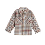 The Mabel + Honey Nicholas Shirt is a long-sleeve plaid flannel button down designed for children, featuring a classic collared neckline, front buttons, and two chest pockets. Crafted from brushed flannel, it showcases beige, brown, and red checkered patterns.
